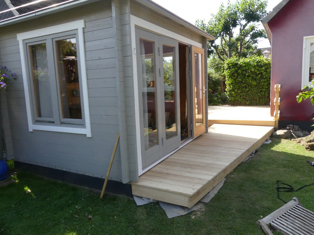 Die Sitzecke im Gartenhaus wird vom Wohnzimmer erreicht, ohne den Rasen betreten zu müssen.